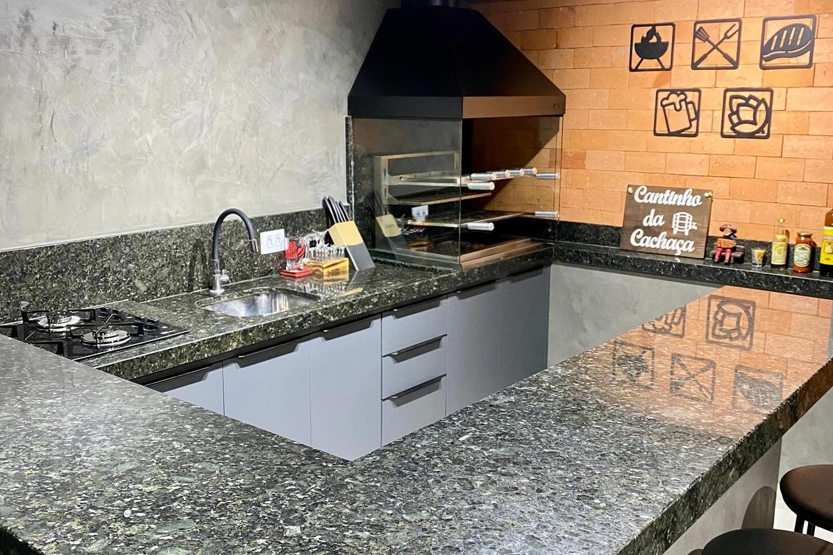 Cozinha com bancada em granito verde e churrasqueira